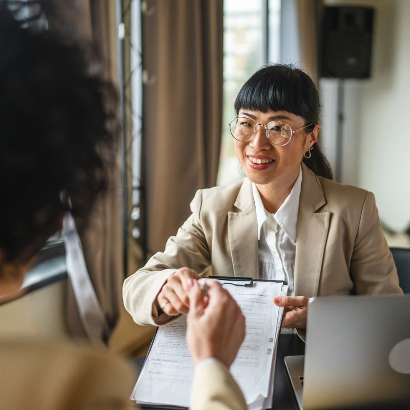 Japanese business woman give contract for signature to client in the office