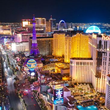 Night view of the Las Vegas Strip with bright lights and iconic landmarks.