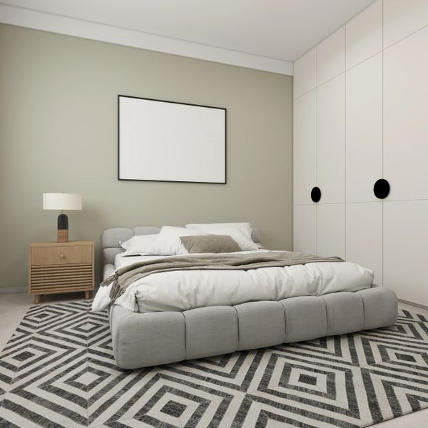 Modern bedroom with gray bed and geometric rug.