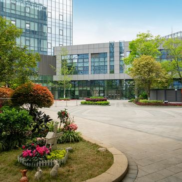 Modern office building with landscaped greenery and flowers.