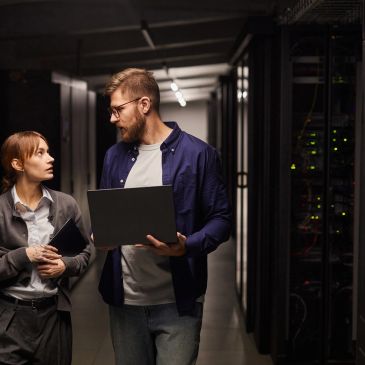 Two IT professionals discussing in a server room.