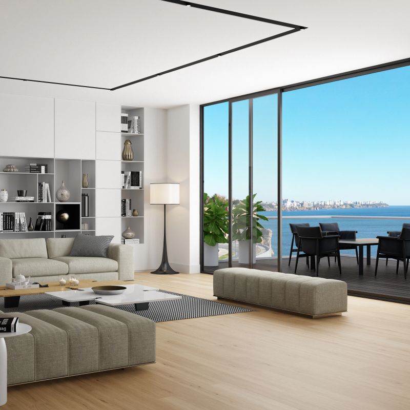 This ultra-modern living room is spacious and filled with contemporary design elements. Large, comfortable sofas invite relaxation, while a sleek, long bench complements the minimalist aesthetic. The walls are lined with bookshelves overflowing with books, vases, and various decorative items, adding personality and style to the room. Ceiling spotlights and hidden LED strips illuminate the space, creating a warm, ambient glow that enhances the modern atmosphere. The combination of modern furniture and elegant décor creates a sophisticated and inviting space for both relaxation and entertaining.Ideal for showcasing modern interior design, luxurious furniture, bookshelves, and innovative lighting solutions in a spacious living area.