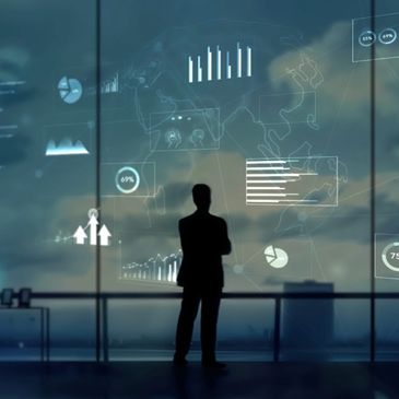 Silhouette of a man analyzing futuristic data and graphs on a large transparent screen.