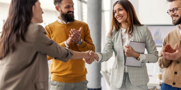 Two women shaking hands during a business meeting.