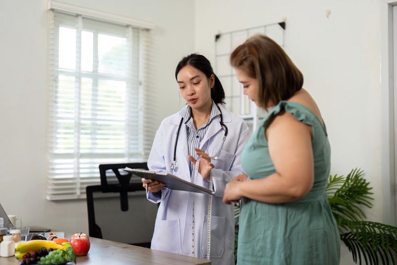 The nutritionist shares insights with a client, using a clipboard during a personalized consultation to discuss healthy eating habits and nutrition goals.