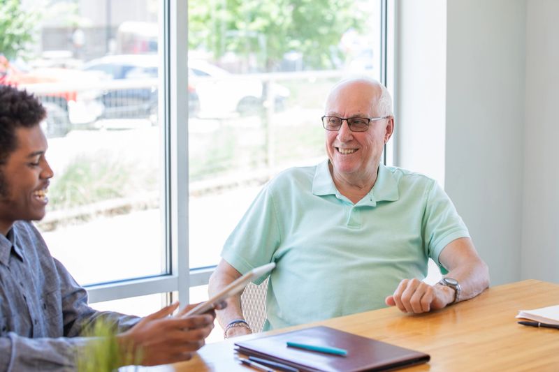 Senior man meets with financial planner to discuss estate planning in office