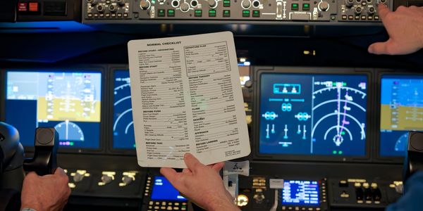 Pilots using a checklist in a modern airplane cockpit during flight.