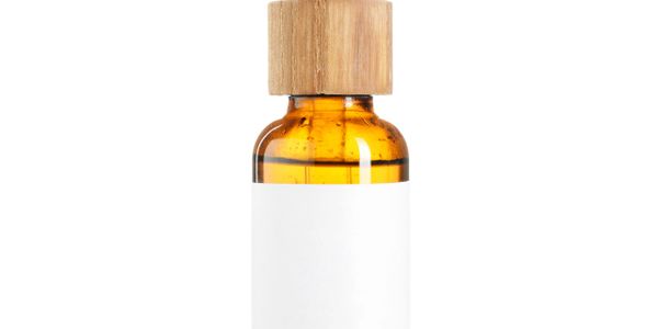 Amber glass bottle with wooden cap and blank white label.