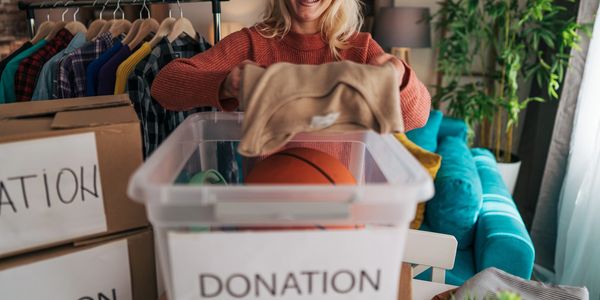Woman donating clothes into a donation box.