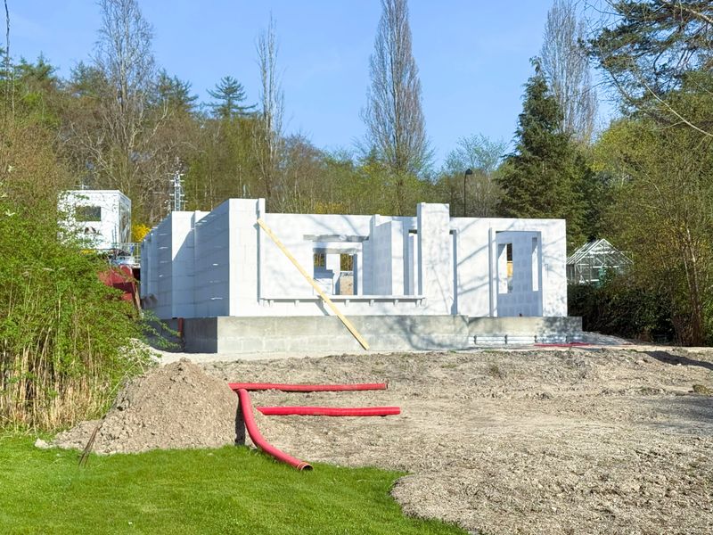 A new residential structure in progress, featuring modern construction techniques using light concrete building blocks. The image captures the raw, unfinished state of the build, highlighting materials, textures, and structural details. Ideal for themes related to construction, real estate development, architecture, engineering, and sustainable building practices.