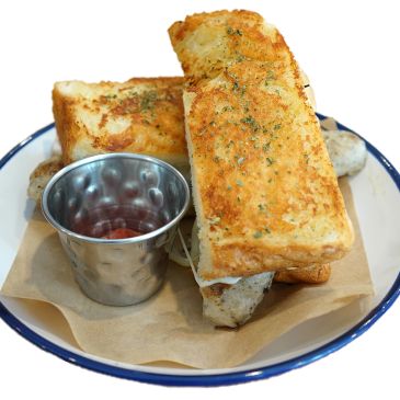 Sausage sandwich with dipping sauce on a plate.