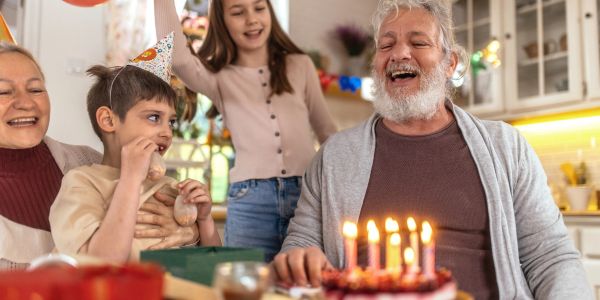 Family celebrating a birthday with cake and candles.