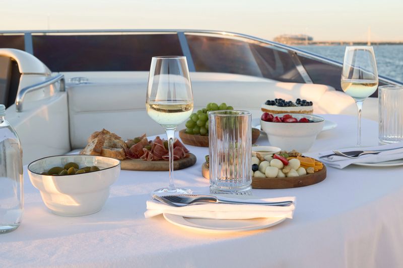 Indulge yourself in a truly lavish dining experience with exquisite fine cuisine enjoyed on a luxurious yacht at sunset