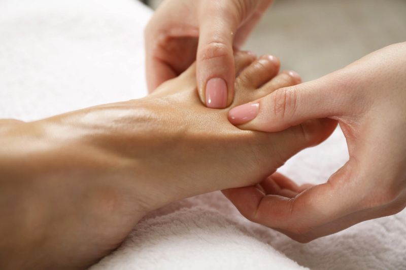Woman receiving foot massage in spa salon, closeup