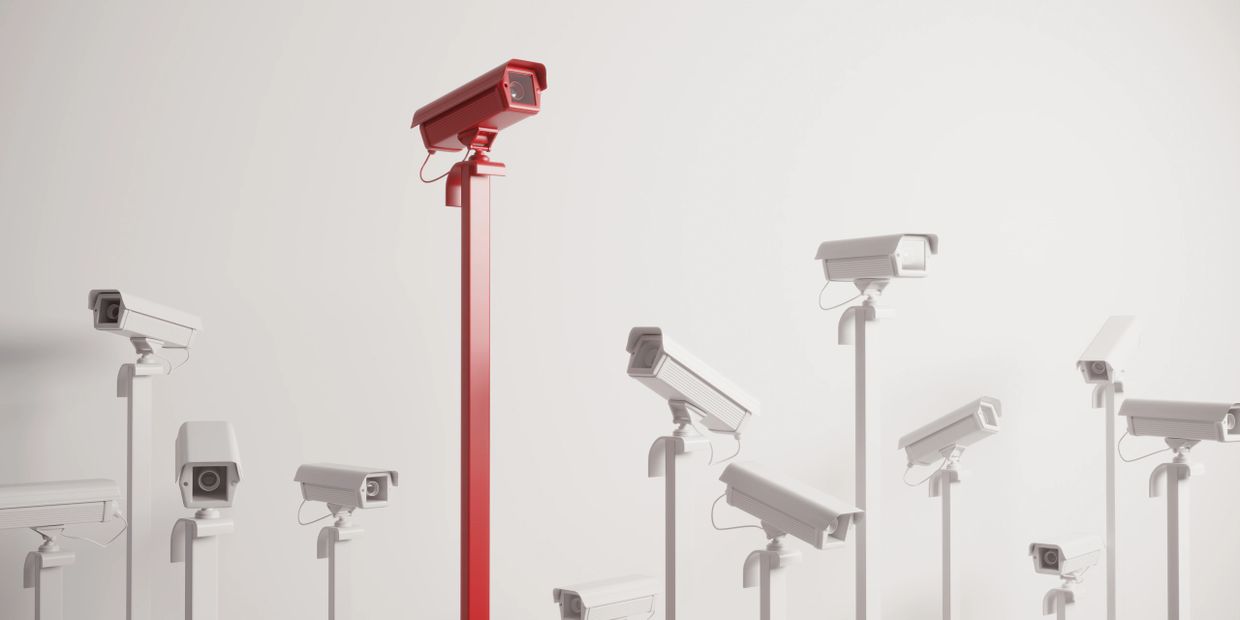 One red security camera stands out among many white ones.