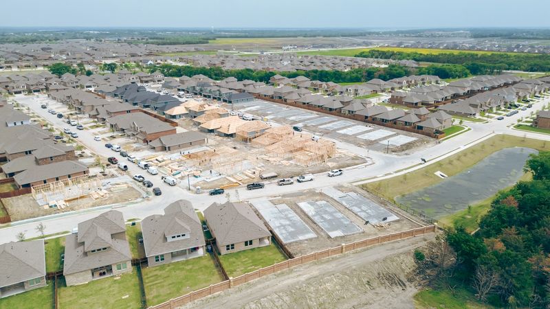 Group of wooden houses under construction in new residential neighborhood with ready moved in two story homes in Princeton, Northeast Collin County, concrete slab foundation on prepping land. USA