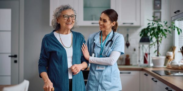 A caregiver assists an elderly woman at home.