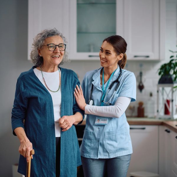 Elderly woman with nurse in kitchen.
