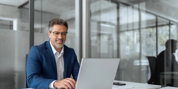 Man working on laptop in modern office.