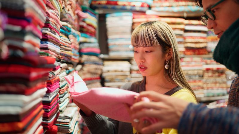 A couple tourist is looking for and choosing textile souvenir in a gift shop in Istanbul, Turkiye.