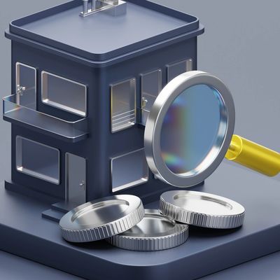 Magnifying glass inspecting coins and a small house model.