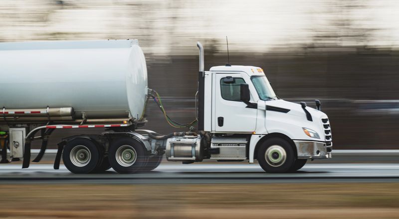 Oil tanker truck on a highway with panning motion blur.