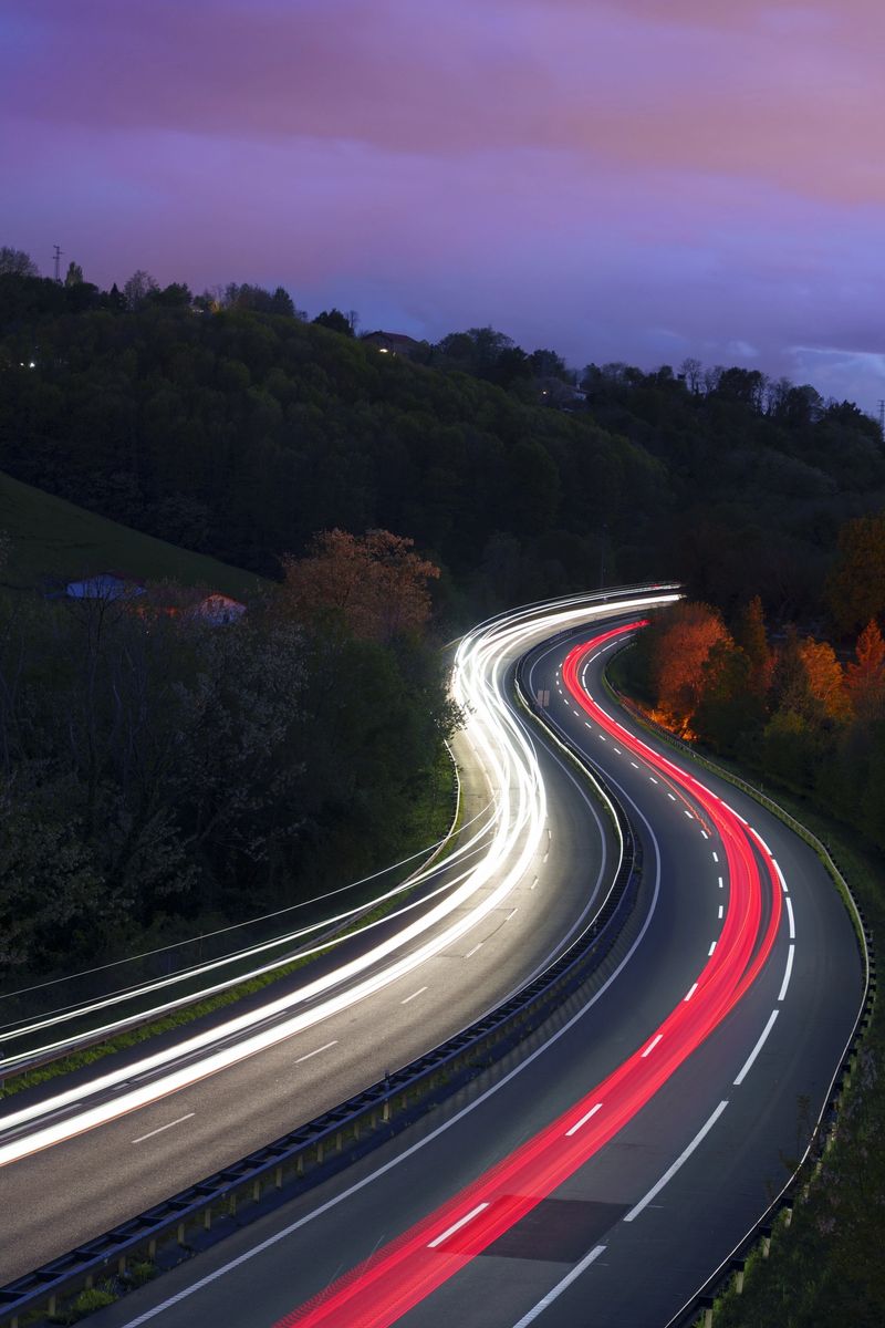 In Euskadi, the vehicle's lights glowed brightly as it moved along the highway, creating a dazzling spectacle in the night.
