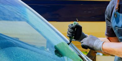 Person repairing a car windshield.