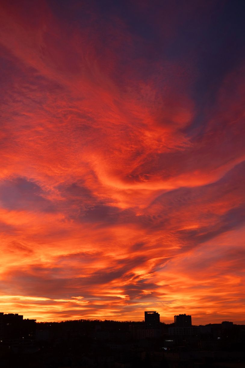 Vibrant orange sunset over city skyline.