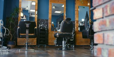 Modern barbershop interior with black chairs and wooden accents.