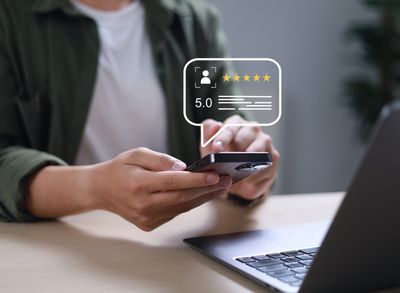 Person holding smartphone with a 5-star rating pop-up over the screen.