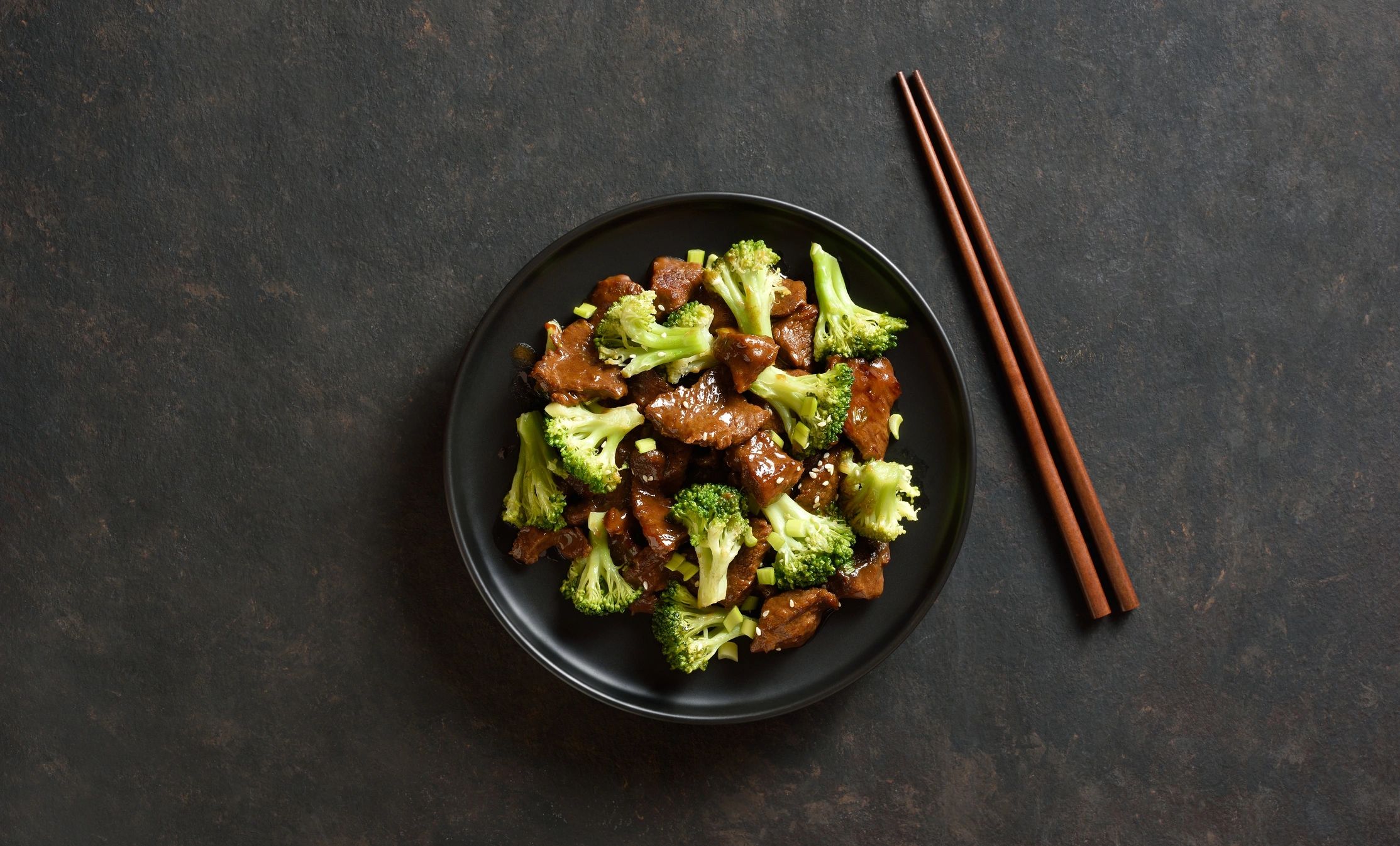 Beef and broccoli stir-fry with chopsticks.