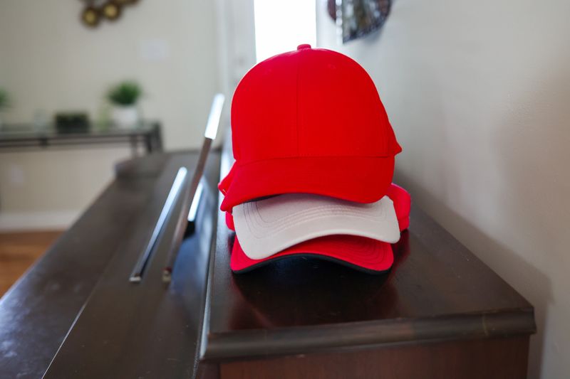 A Stack Of Baseball Caps On A Table