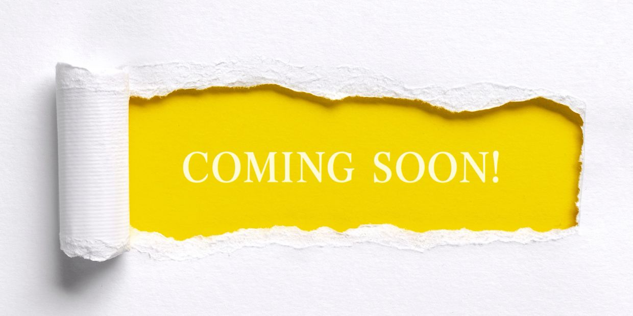 Torn white paper reveals a bright yellow background with 'COMING SOON!' text.