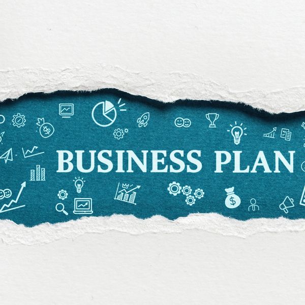 Torn paper revealing the words BUSINESS PLAN with business icons on a blue background.