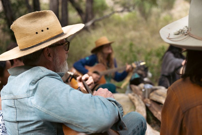 A multi ethnic group of friends laughing and relaxing in a natural outdoor setting. Camping with tent.