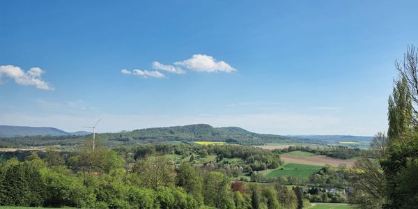 Scenic countryside with green fields and a clear blue sky.