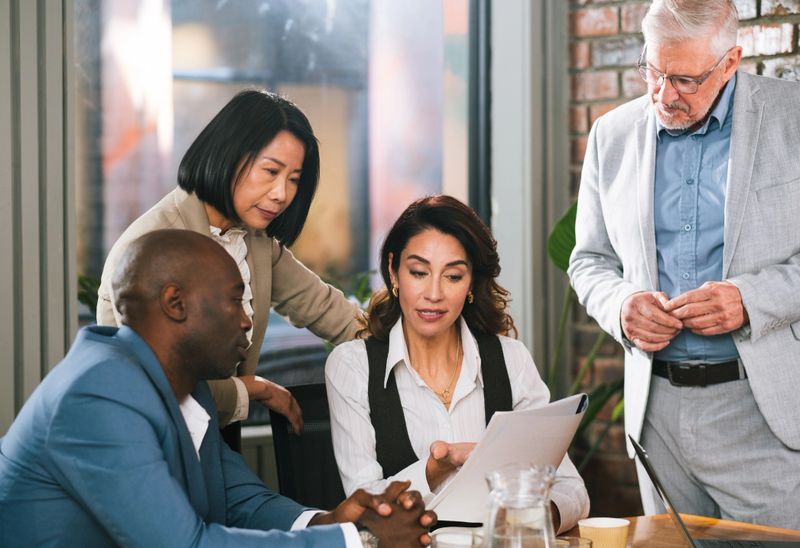 Collaboration, colleagues and people with documents, office and lawyer with engagement letter for case. Law firm, attorney and clients with paperwork for legal strategy, discussion and plan for trial