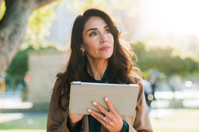 Thinking, employee and woman with tablet, outdoor and ideas for listing on website and real estate agent. Contemplating, real estate agent and mature person with tech for market research, online and planning