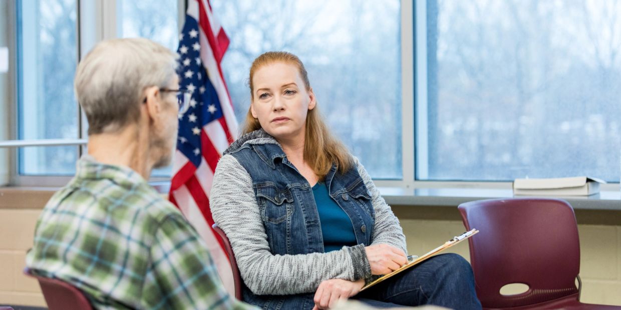 Woman attentively listening to an elderly man in a discussion.