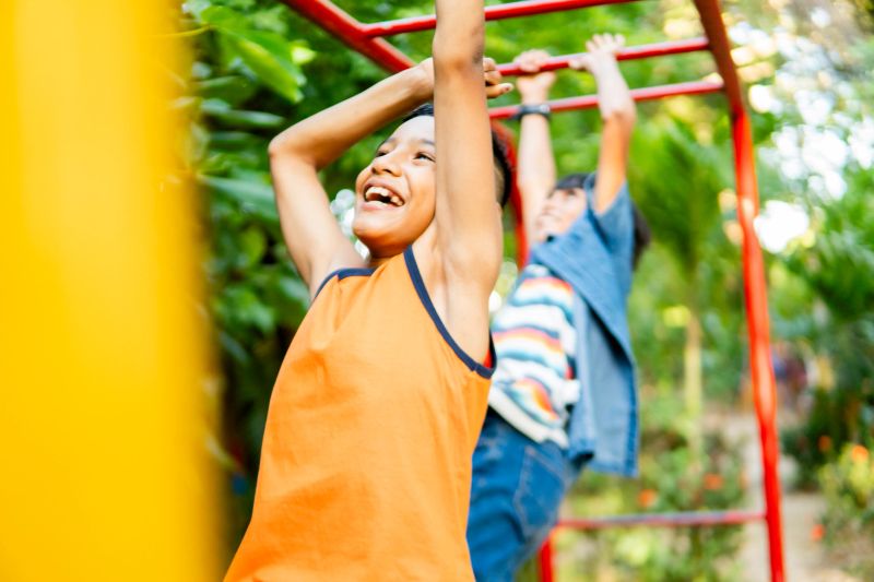 Two latin american elementary age children are having fun in a playground