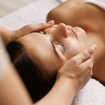 Mujer recibiendo masaje facial relajante.
