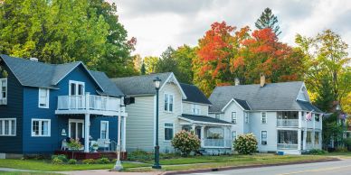 Row of colorful suburban houses with fall foliage.