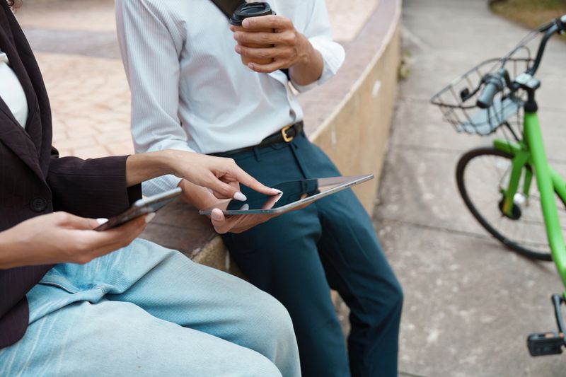 Seated outside with coffee, two friends brainstorm sustainable initiatives, merging casual conversation with a focus on environmental advocacy.