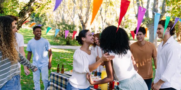 Friends enjoying a colorful outdoor party with decorations and food.
