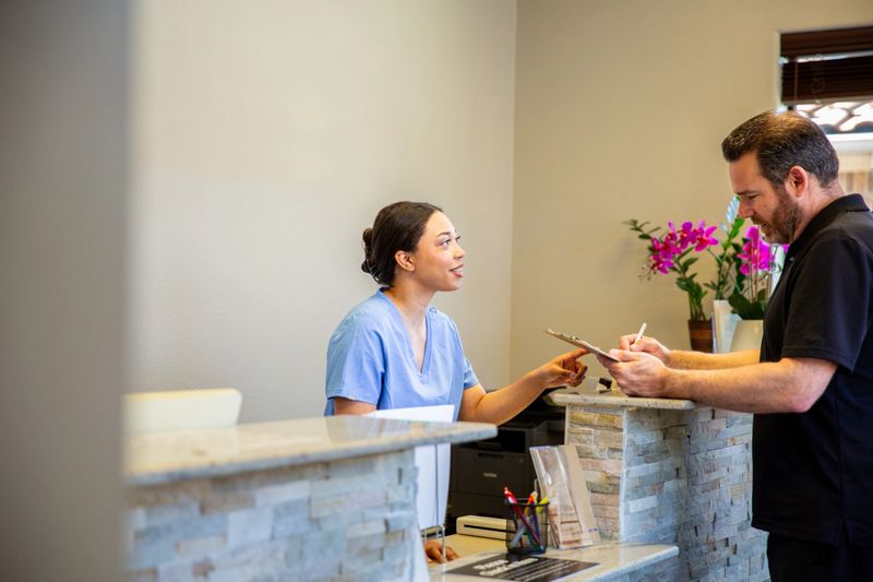Patients and nurses in the waiting room interacting and checking in