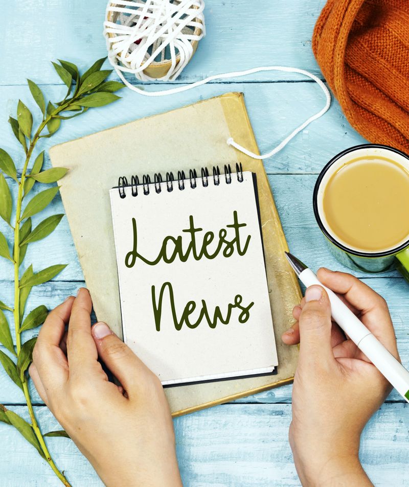 Handwriting Latest News on Notebook with Cozy Desk Items