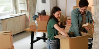 A couple happily unpacking boxes in their new home.