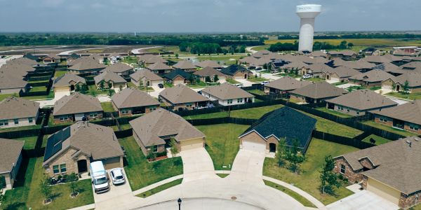 A suburban neighborhood with single-story houses and a water tower.