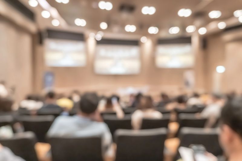 Seminar conference or town hall meeting blur background in auditorium or hotel room with audiences, speaker podium stage and presentation screen for entrepreneurship business speech or community talk